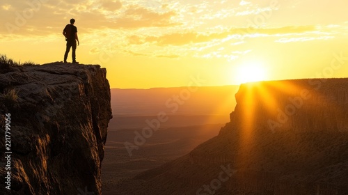 Man Contemplating Sunset Over Canyon Rim