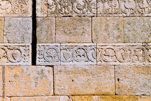 Detail of ancient 7th-century Visigothic carved stone bas-reliefs on the exterior wall of the Hermitage of Santa Maria de las Vinas in Burgos, Spain.