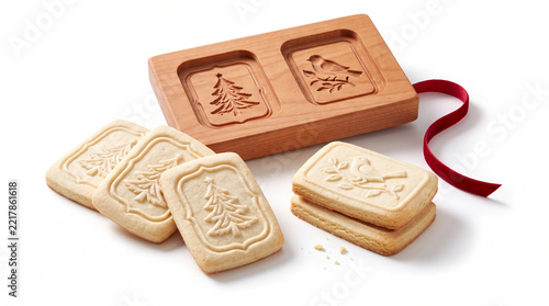 Molded Christmas cookies with wooden mold isolated on white background.