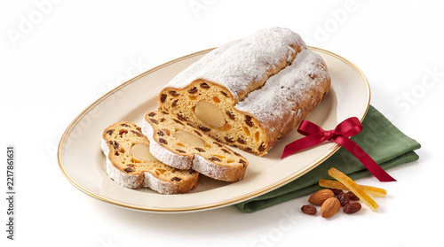 Sliced stollen with powdered sugar isolated on white background.