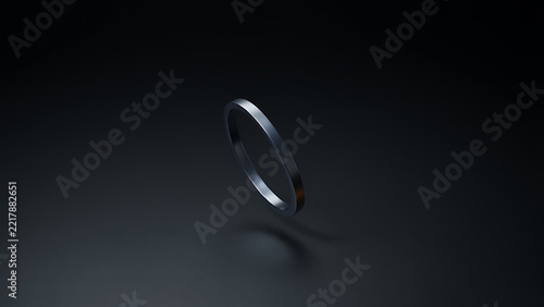 A thin, metallic ring, possibly a band or a simple bracelet, floats in a dark, minimalist environment, with subtle reflections of light highlighting its smooth, polished surface