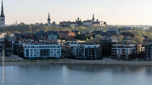 Medieval towers of Tallinn Old Town rising above new residential buildings on the seafront, aerial telephoto shot, Estonia