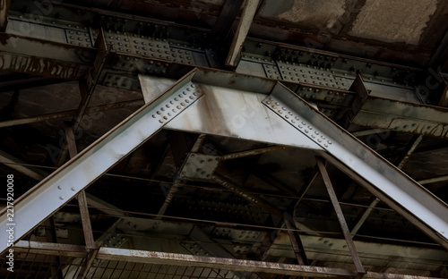 Low key view of heavy metal bridge support framework.