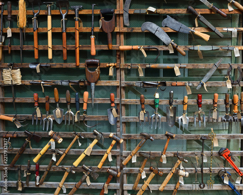 Vintage and antique garden tools and hand implements mounted on a wooden wall rack