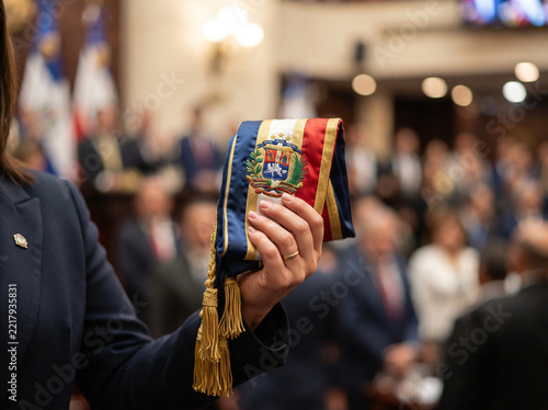 Official holding the presidential sash with the national coat of arms of the Dominican Republic during a formal government ceremony