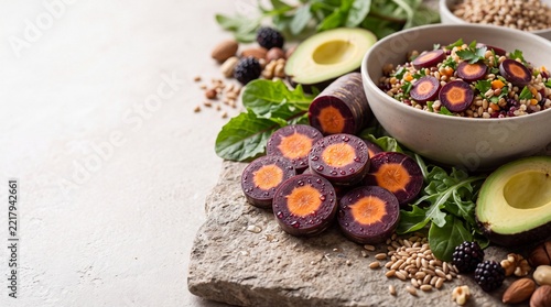 Sliced Purple Heirloom Carrots with Grain Salad, Avocado, Berries, and Nuts on Stone Board