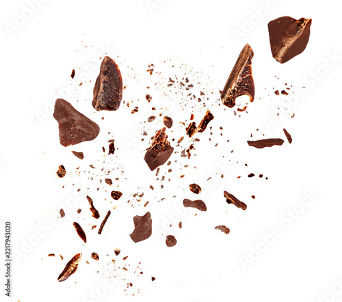 Levitating Dark chocolate crumbs  floating isolated on white background. Grated chocolate pieces  explotion. Chocolate  top view. Flat lay
