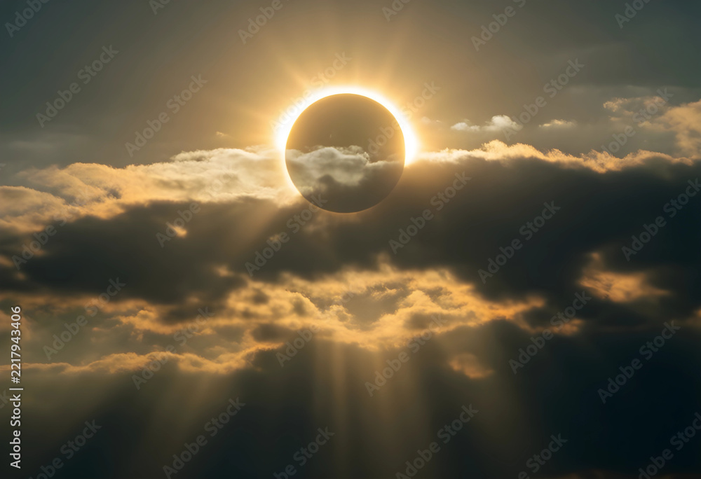 Fototapeta premium Solar eclipse and celestial event, astronomical phenomenon with sun rays breaking through dark clouds in the sky during a rare total solar eclipse
