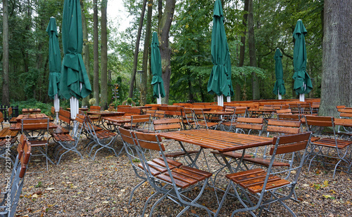 verlassene Terrasse einer Waldgaststätte, Gaststätte mit grünen Sonnenschirmen, Tischen und Stühlen, Außengastronomie im Wald