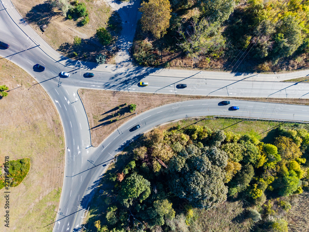 Fototapeta premium Traffic observed from above at a roundabout in a suburban area during daytime