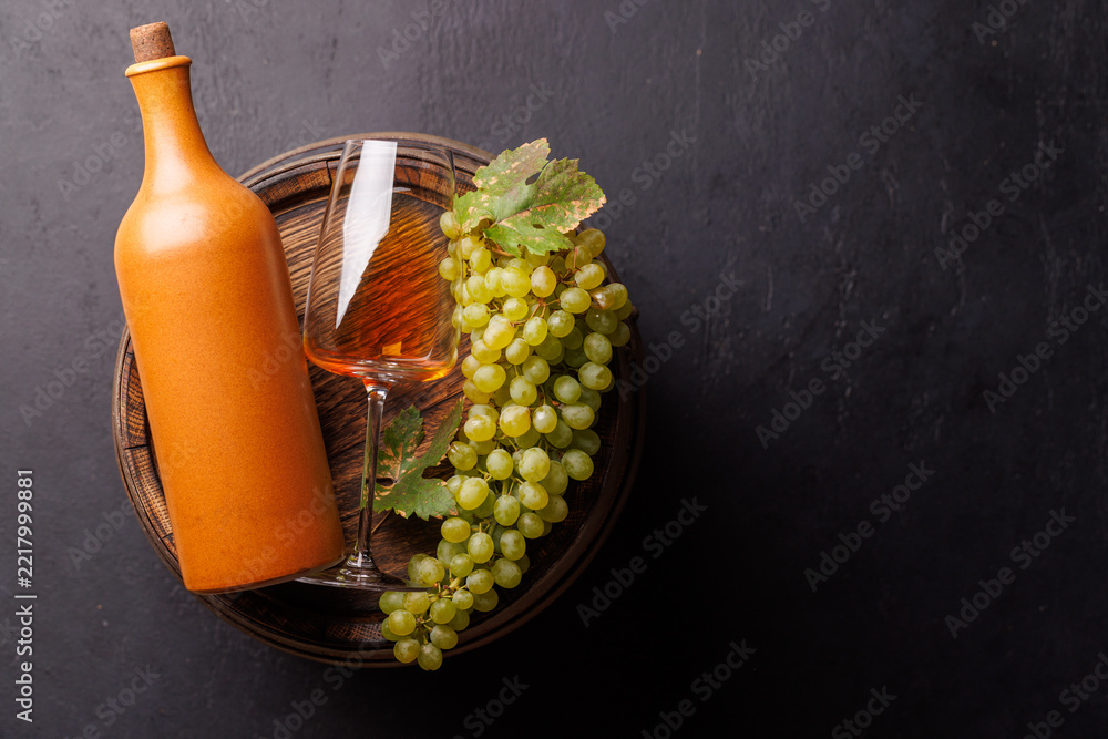 Fototapeta premium Terracotta wine bottle with grapes and rose glass