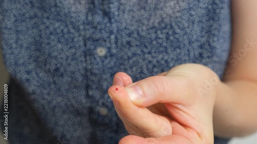 Using lancet device to prick finger for blood sugar test close up.