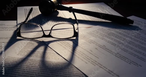 Reading Glasses and Judge Gavel Resting on Legal Contract Documents