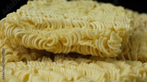 Extreme close up of yellow wavy dry noodles spinning slowly