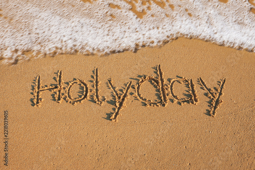 Welle am Strand mit Schrift Holyday