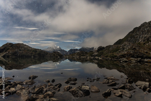 Starlit mountain lake reflection at night in Daocheng Yading
