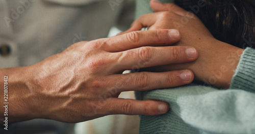 Close up young Hispanic husband comforting sad depressed wife on sofa in home living room. Mental health support, marriage couple conflict problem, grief emotion therapy, family trauma crisis concept.