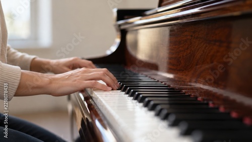 Pianist Hands Playing Grand Piano During Elegant Music Lesson Displays Polished Ivory Keys and Rich Wood Grain in Soft Natural Light