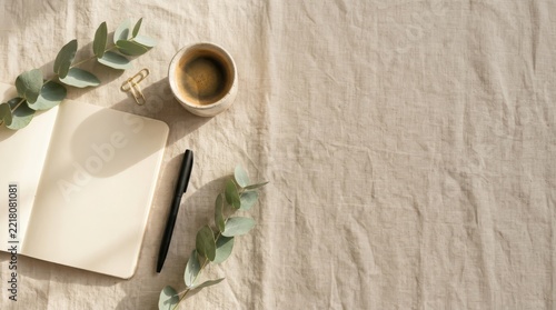 Minimalist flat lay with open notebook coffee cup and eucalyptus on