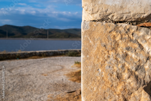 Ancient Stone Block Closeup With Lake and Hills Background