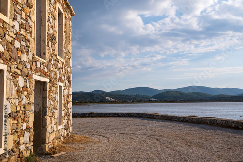 Rustic Stone Building by Calm Lake with Mountain View
