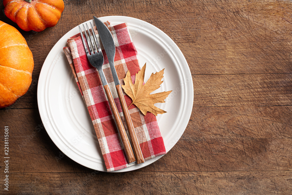 Fototapeta premium Autumn table setting with pumpkins and maple leaf on wooden background