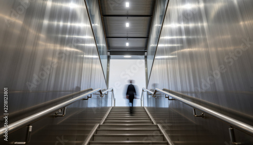 Low angle staircase with blurred person in modern metal corridor