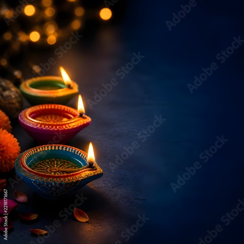Traditional Diwali diya lamps glowing with marigold flowers on dark