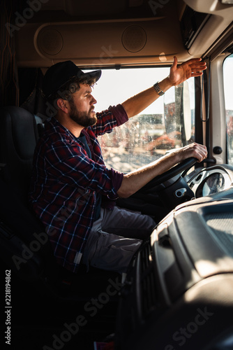 Truck driver navigating in cabin of large vehicle during daylight