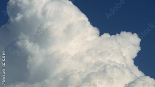Cumulus clouds moves in the blue sky. The background of light and heavy calm clouds changes shape in cloudy space.