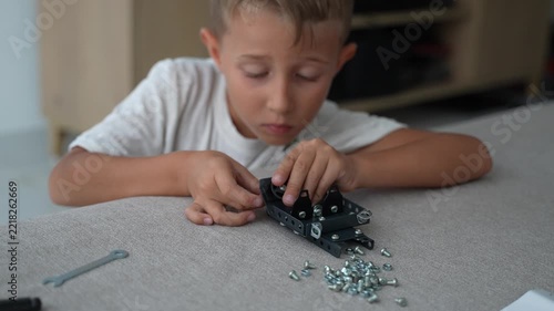 Child Building a Metal Construction Kit with Screws and Tools