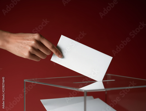 Mano introduciendo su voto en una urna
