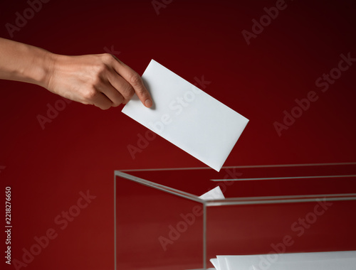 Mano introduciendo su voto en una urna