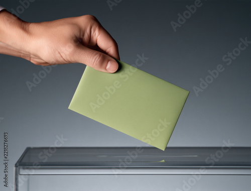 Mano introduciendo su voto en una urna