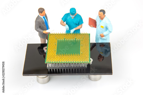 Miniature people working around a circuit board in a lab on a project during the day