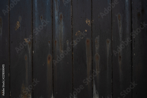 Weathered black painted wood texture with exposed grain and patches of worn paint