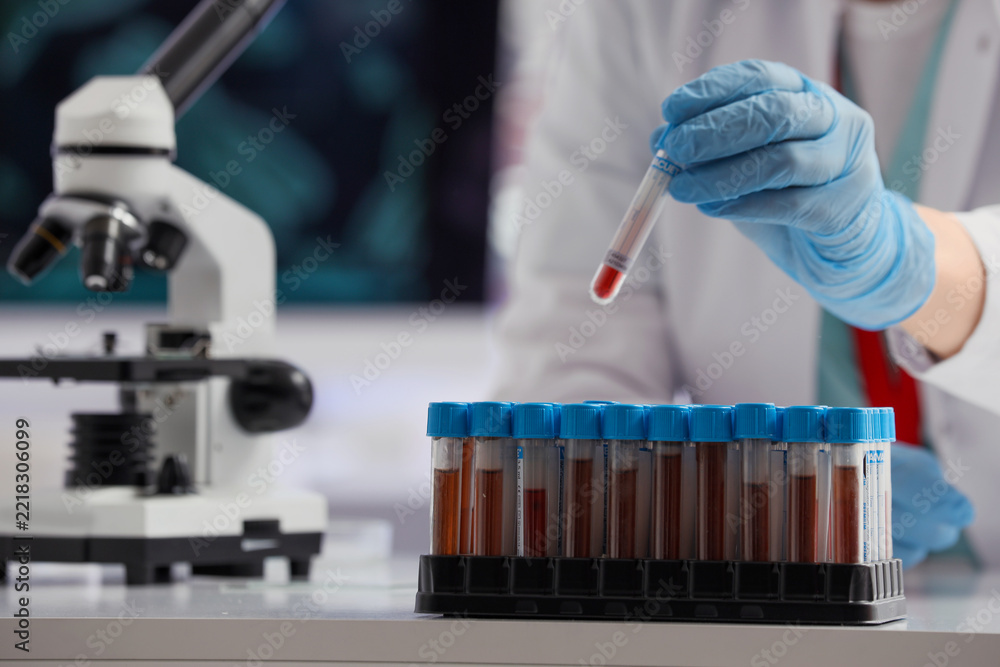 Fototapeta premium Medical diagnostics and blood testing, scientist holding a test tube with sample in a clinical laboratory for pathology research and disease screening