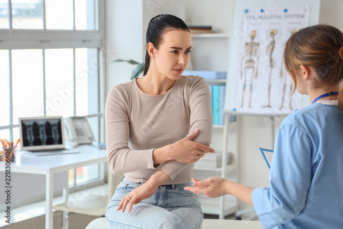 Medical consultation and joint pain, patient describing elbow injury to docto...