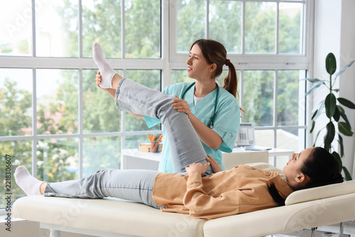 Physical therapy and rehabilitation, physiotherapist examining patient leg mo...