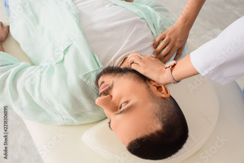 Chiropractic adjustment and physical therapy, doctor examining neck pain of a...