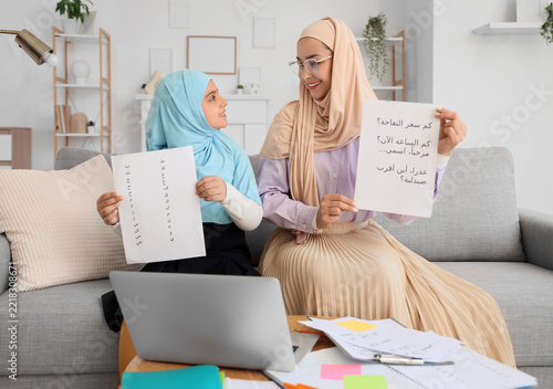 Arabic language learning, mother and daughter practicing reading and writing ...