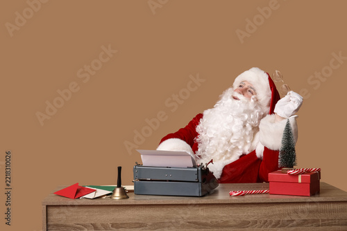 Santa Claus with vintage typewriter, envelopes, gift box, candy canes and jin...