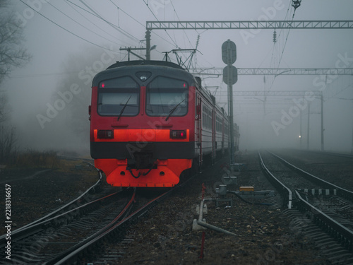 The commuter train is moving through thick fog.