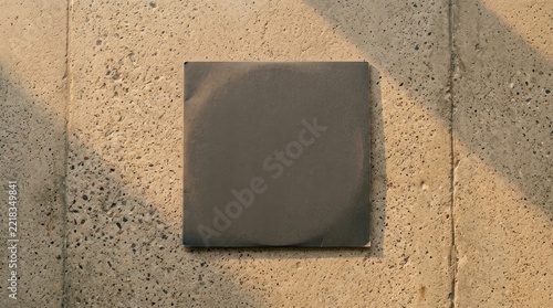 Dark grey square card mockup on sunlit concrete.