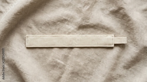 Long blank fabric label on textured linen background.