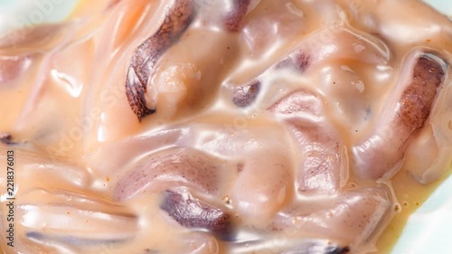Close-up macro shot of traditional Japanese ika no shiokara fermented squid delicacy with salted preservation