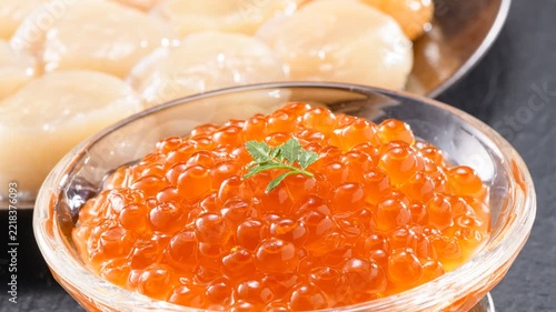 Golden salmon roe cured in soy marinade presented in elegant glass bowl with herb garnish
