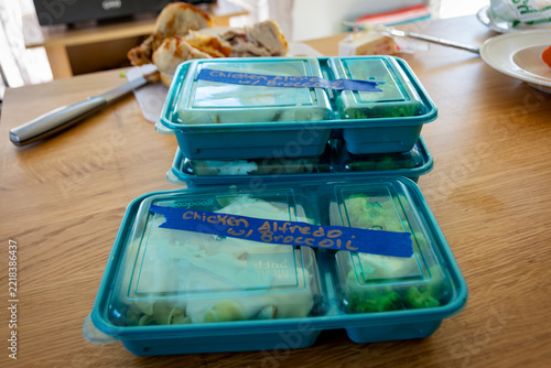 Meal Prep Easy Chicken Alfredo: labeled lidded meal prep containers packed with chicken alfredo and broccoli.
