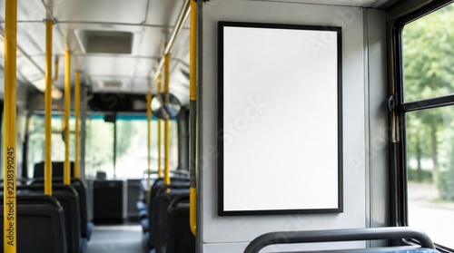A blank white poster in a black frame inside the bus