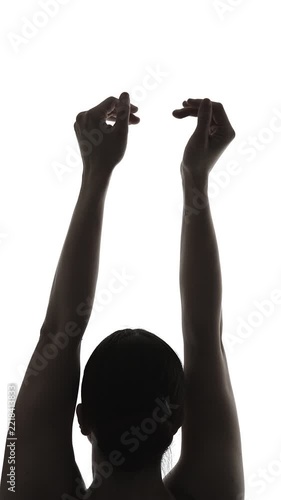 Close up of female ballet dancer in silhouette performing graceful arm movements in studio